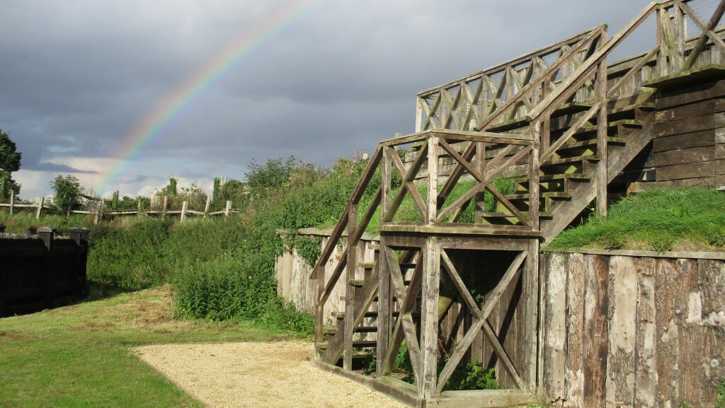 Lunt Roman Fort structures with a rainbow in the sky